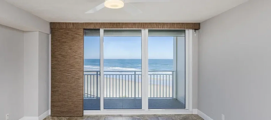 Primary bedroom sliding doors opening to the Atlantic